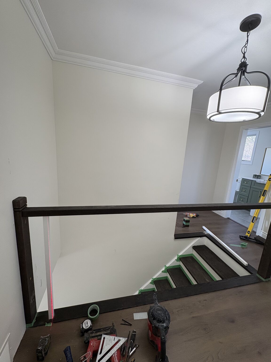 Custom railing being built with dark stained posts and pendant lighting by Bulldawgs Construction