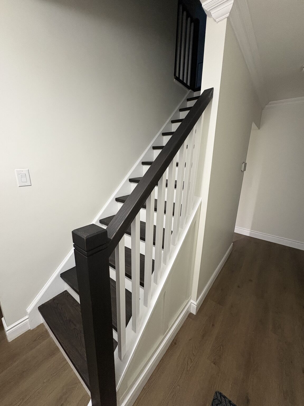 Completed newel post and railing with dark stain and white spindles - Bulldawgs Construction Cambridge Ontario